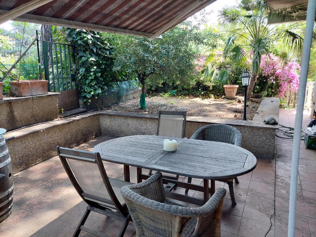 a wooden table and chairs on a patio at Appartamento con giardino in zona Ponte Milvio e Stadio Olimpico in Rome