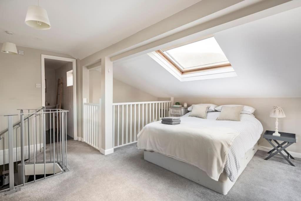 a white bedroom with a bed and a skylight at Gorgeous 1 bedroom residential home In Sudbury. in Sudbury