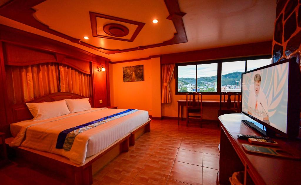 a bedroom with a bed and a flat screen tv at Tiger Complex Hotel in Patong Beach