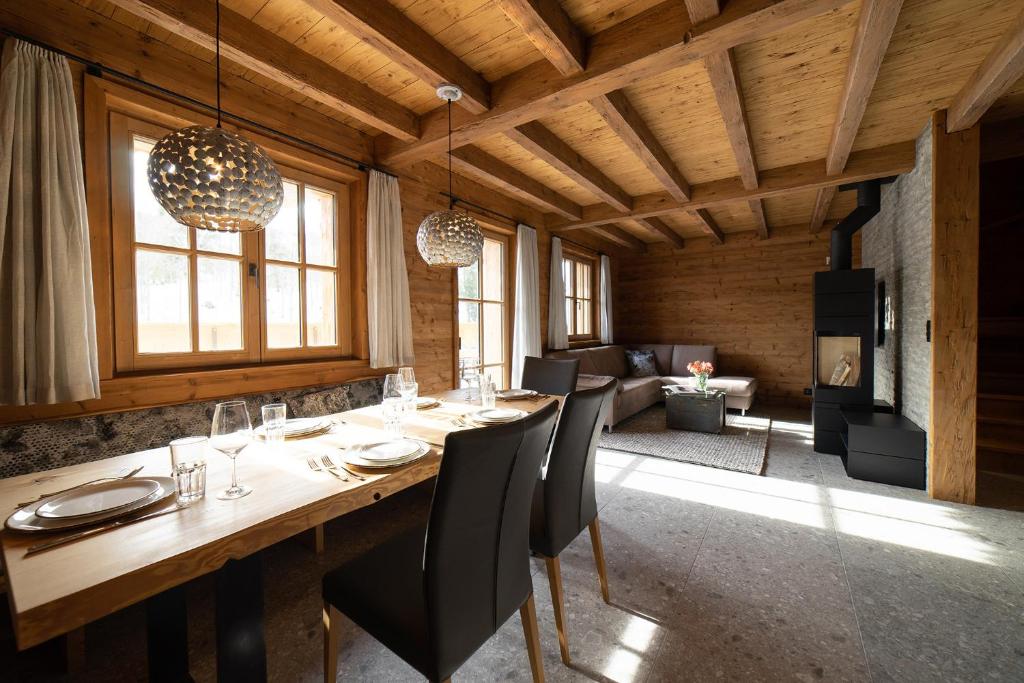uma sala de jantar com uma longa mesa de madeira e cadeiras em Chalet Selun em Wildhaus