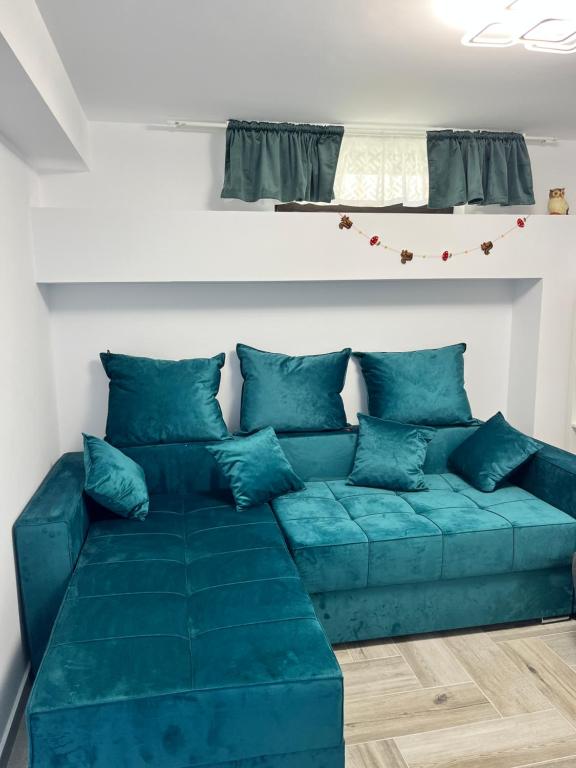 a blue couch with blue pillows in a living room at Apartament Eroilor in Lunca Cetăţuii