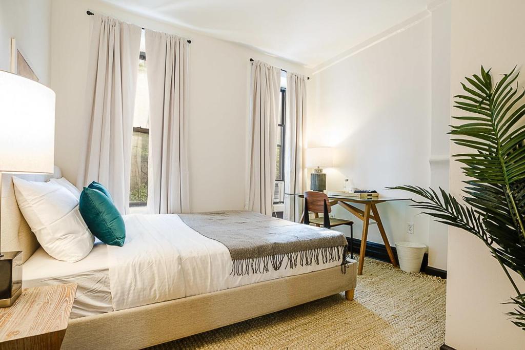 um quarto com uma cama, uma secretária e uma janela em Apartment 189: Upper East Side em Nova York