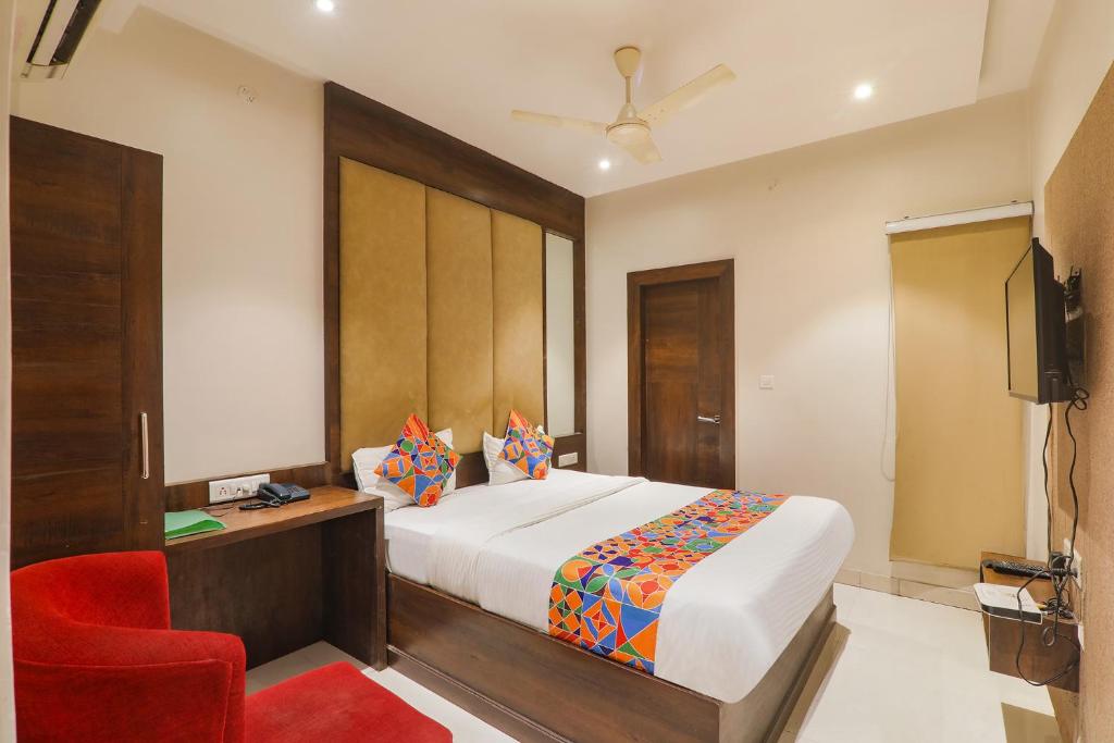 MuthiganjにあるFabHotel Stay Inn Iのベッドルーム1室(ベッド1台、赤い椅子付)
