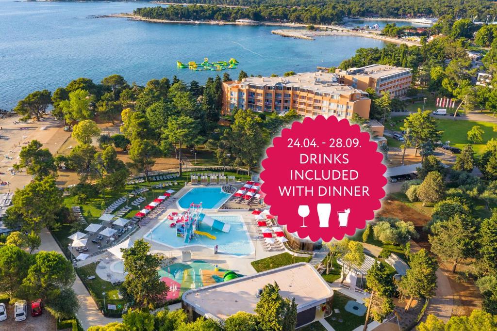 an overhead view of a water park with a sign that reads drinks included with dinner at Hotel Umag Plava Laguna in Umag