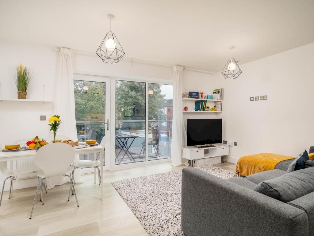uma sala de estar com um sofá e uma mesa em Pass the Keys Central and Modern 2 Bed Flat 6ppl em High Wycombe