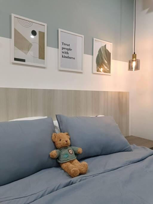 un ours en peluche assis au-dessus d'un lit dans l'établissement Cozy Studio Retreat @Queenville Bandar Permaisuri, à Kuala Lumpur