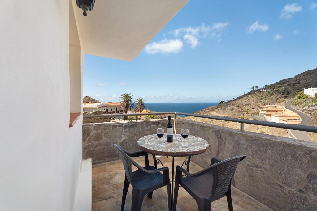 a table and chairs on a balcony with a view of the ocean at Vivienda vacacional La Era in Vallehermoso