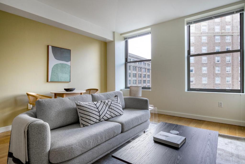 a living room with a couch and two windows at Back Bay 1br w gym wd close to garden BOS-942 in Boston