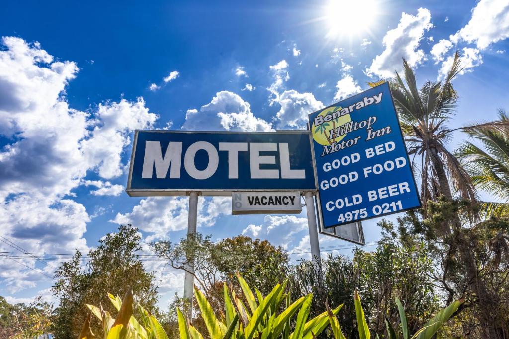 un cartel de motel con el sol en el cielo en Benaraby Hilltop MotorInn, en Benaraby