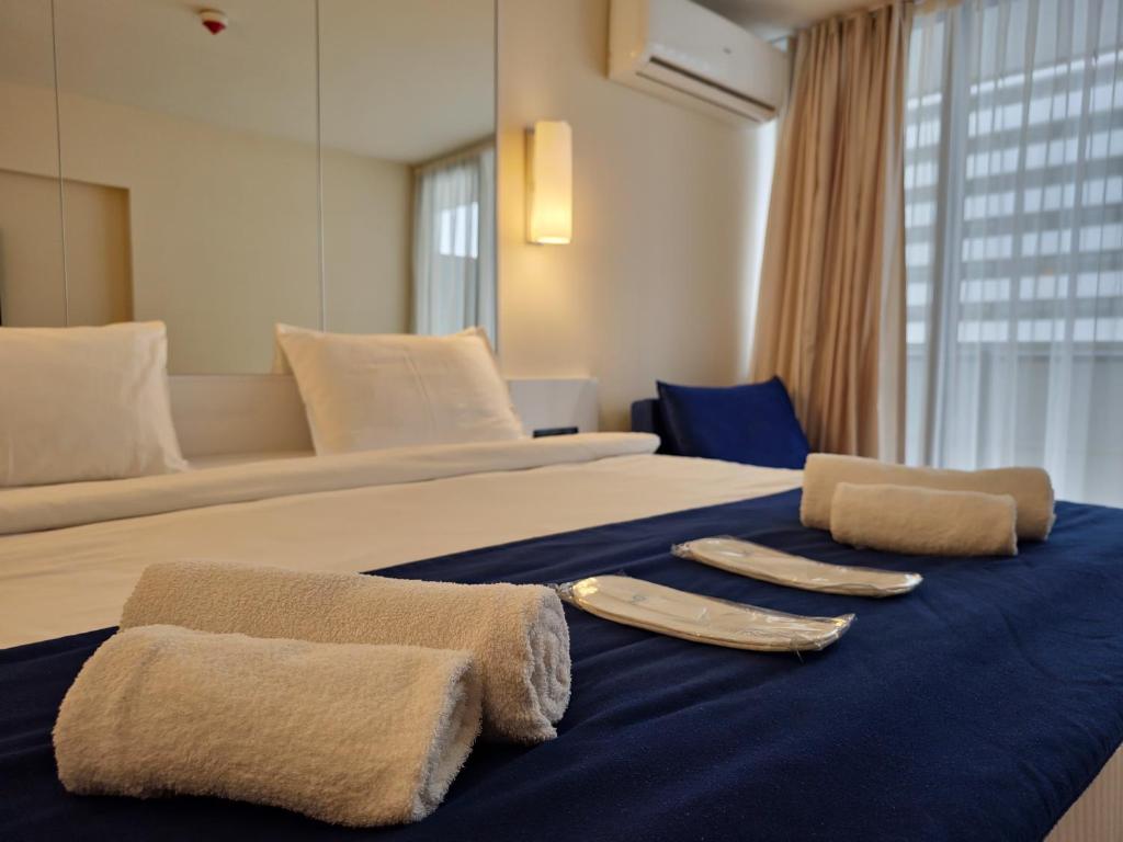 ein Hotelzimmer mit einem Bett mit zwei Utensilien darauf in der Unterkunft ORBI Sea Breeze ApartHotel in Batumi