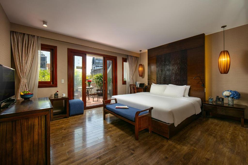 a bedroom with a bed and a living room with a television at Oriental Suites Hotel & Spa in Hanoi