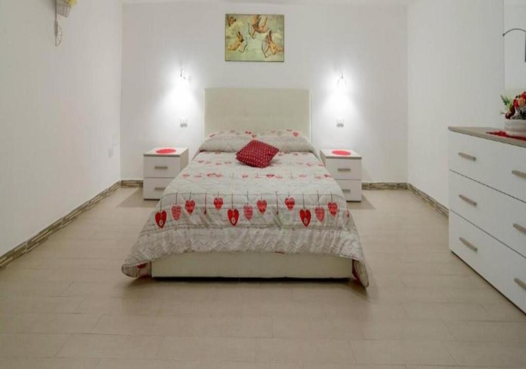 ナポリにあるMaurizio e Alessia Houseのベッドルーム1室(ベッド1台、ナイトスタンド2台付)