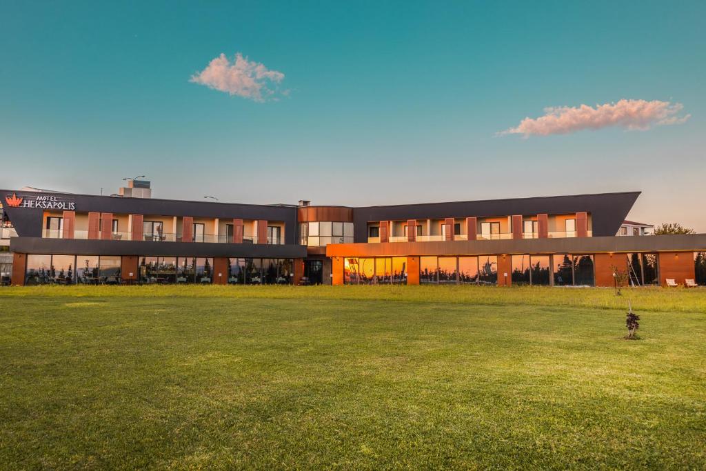 a large building with a field in front of it at HOTEL HEKSAPOLİS in Tavşancıl