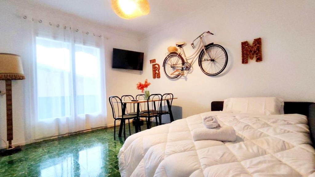 1 dormitorio con 1 cama y una bicicleta colgada en la pared en THE ROOM - APARTMENT IN LLORET en Lloret de Mar