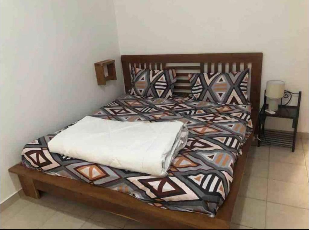 two twin beds in a room with a table at joli appart 2 chambres salon liberté 6 extension in Dakar