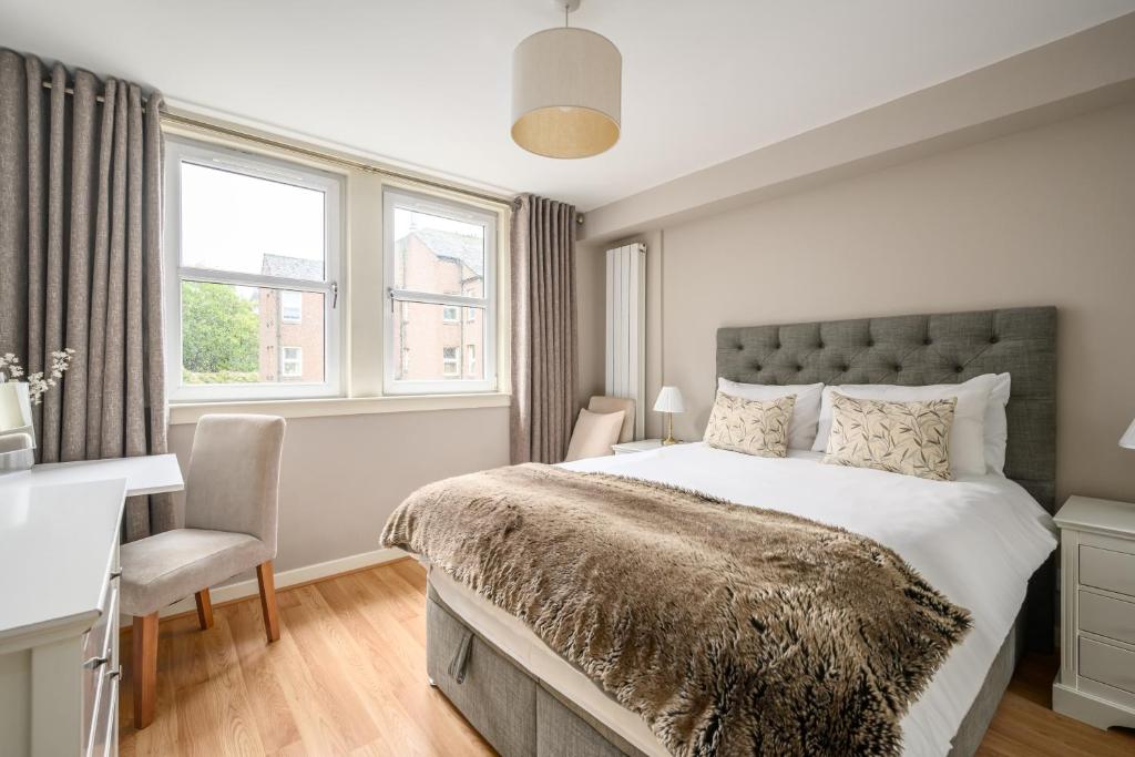 - une chambre avec un lit, une chaise et des fenêtres dans l'établissement Castle View Hideaway, à Édimbourg