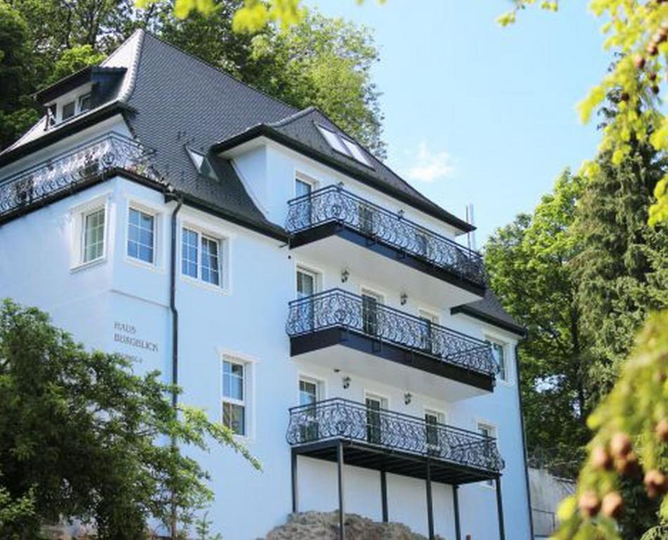 a white building with balconies on top of it at Haus Burgblick in Badenweiler
