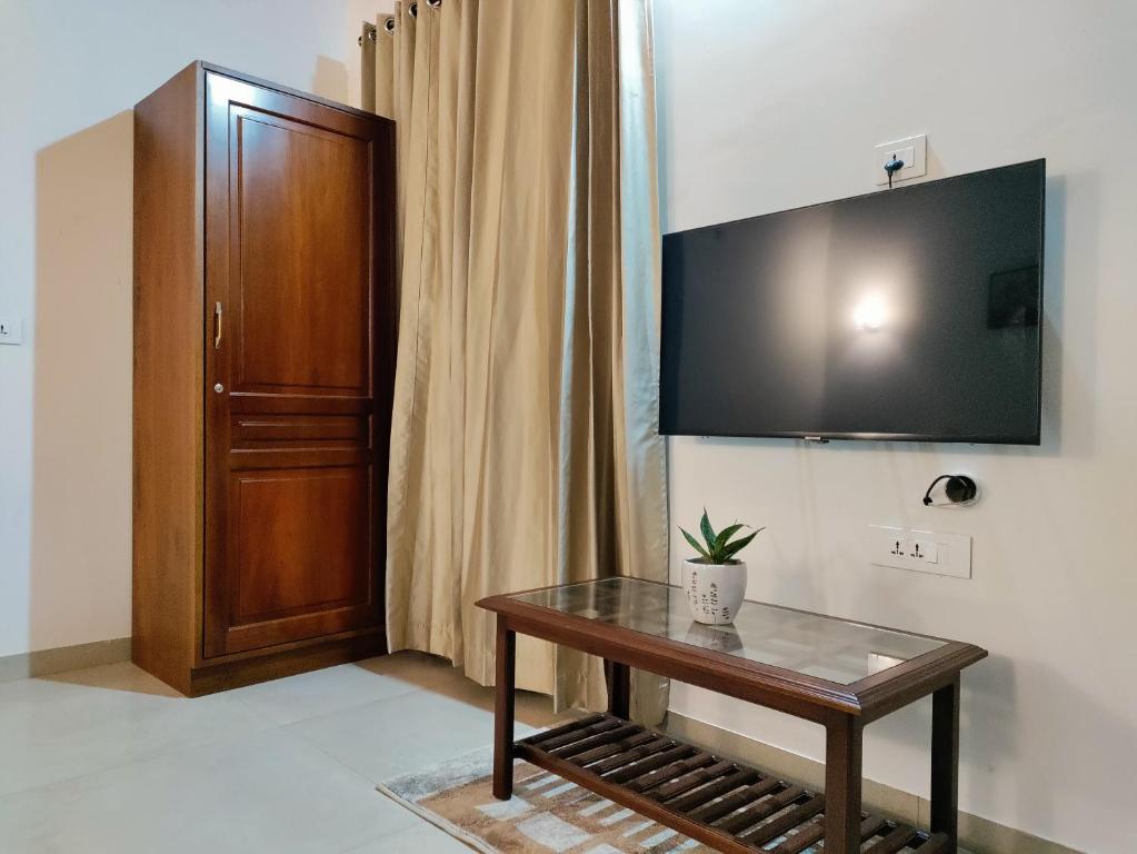 a room with a table and a television on the wall at The Cana's Coorg in Ammatti
