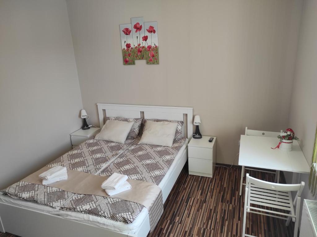1 dormitorio con cama, mesa y escritorio en BarBen Apartman, en Mórahalom