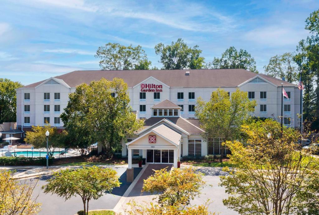an exterior view of a hotel with trees at Hilton Garden Inn Montgomery East in Montgomery