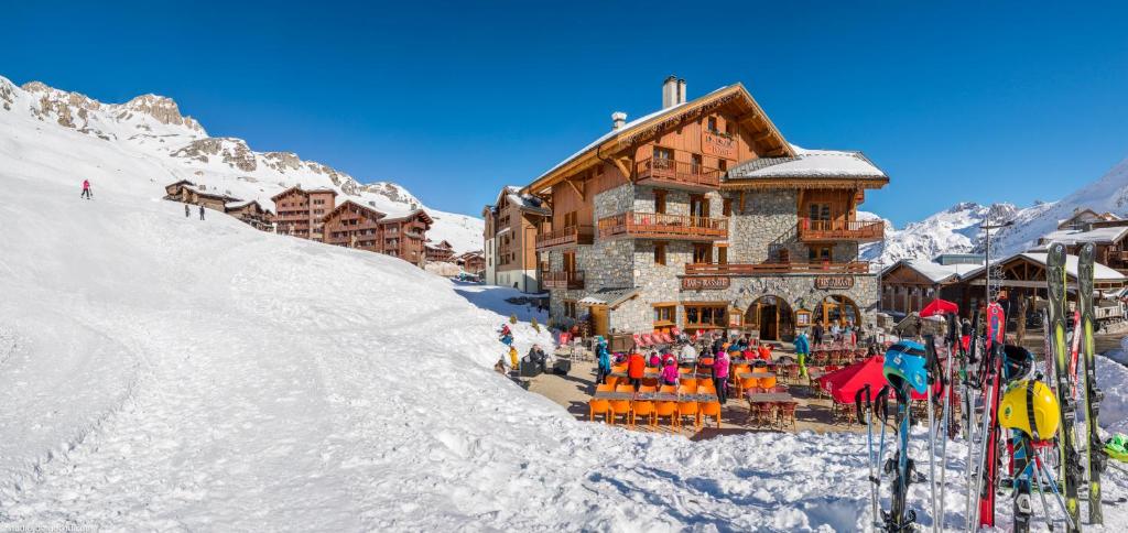 a ski lodge on a snowy mountain with skis in the snow at Résidences Village Montana by Les Etincelles in Tignes