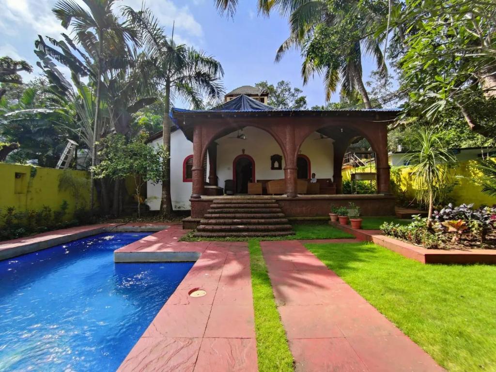 uma casa com uma piscina e um gazebo em Siolim Villa Goa 3 bhk em Siolim