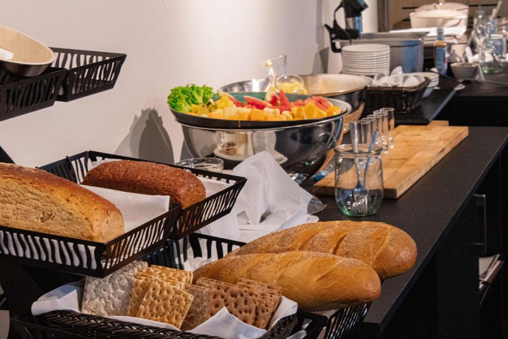 a table topped with baskets of bread and other foods at Best Western Plus Hotel Ilulissat in Ilulissat