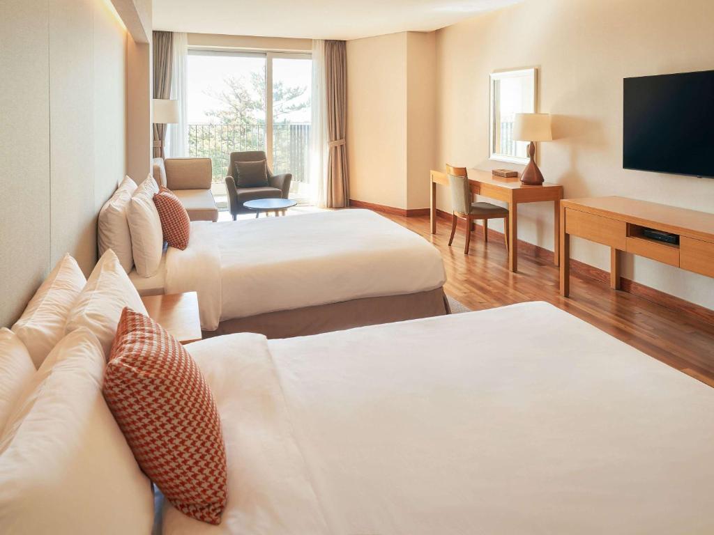Postel nebo postele na pokoji v ubytování Mercure Ambassador Jeju