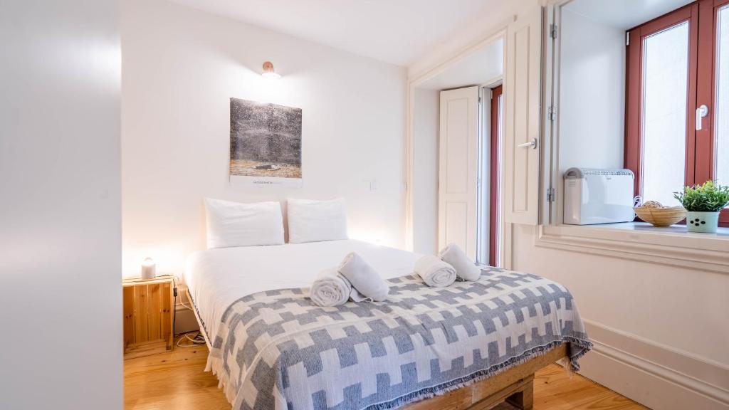 Un dormitorio blanco con una cama con toallas. en Taipas Tranquility: Cozy T0 by LovelyStay, en Oporto