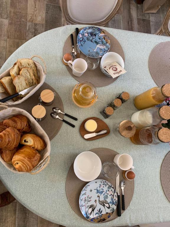 a table topped with plates and bowls of pastries at Chambre Les Chérubins in Lorris