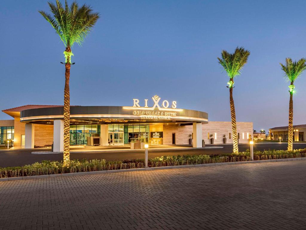 un edificio con palmeras delante en Rixos Golf Villas And Suites Sharm El Sheikh en Sharm El Sheikh