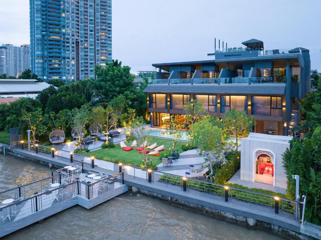 a building on the river in front of a city at Ten Six Hundred, Chao Phraya, Bangkok by Preference, managed by The Ascott Limited in Bangkok