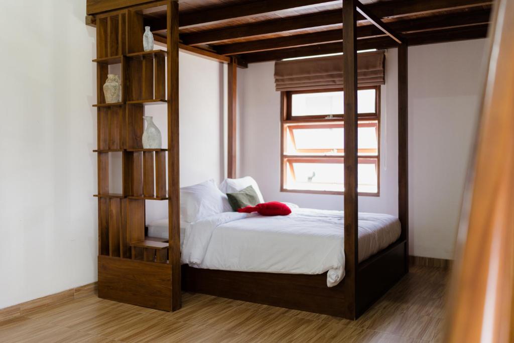 Schlafzimmer mit Himmelbett und Fenster in der Unterkunft d Ha'te in Tasikmalaya