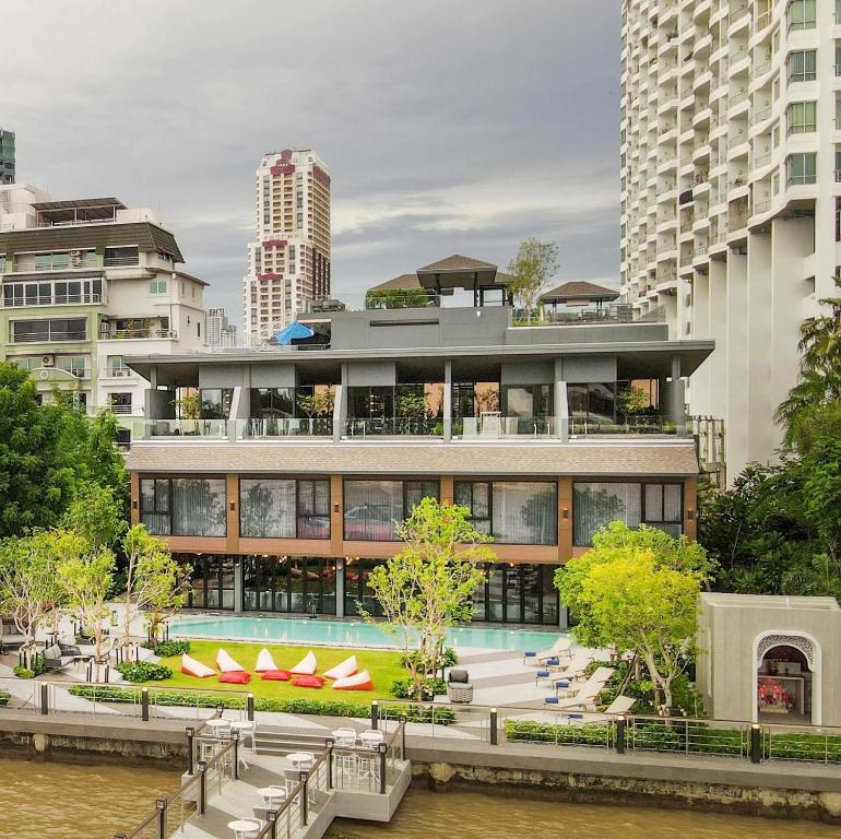An elevated outdoor pool complex beside the river and hotel building.