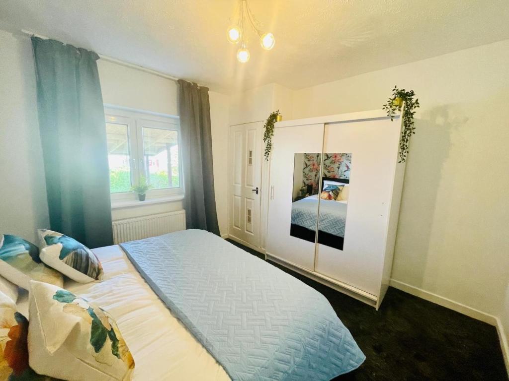 ein Schlafzimmer mit einem großen Bett und einem Fenster in der Unterkunft Mitchell Apartment by Klass Living Coatbridge in Coatbridge