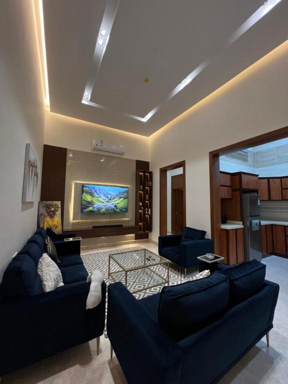 a living room with two blue couches and a tv at شقه غرفتين وصاله دخول ذاتي (حي النرجس) in Riyadh
