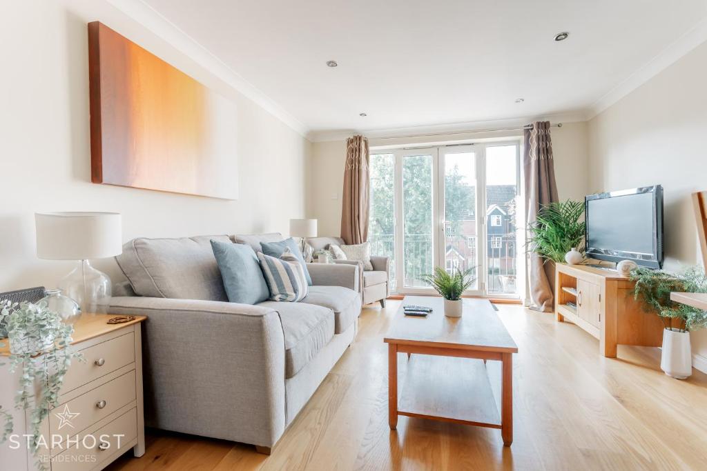 a living room with a couch and a tv at Modern 2 bed apartment at Imperial Court, Newbury in Newbury