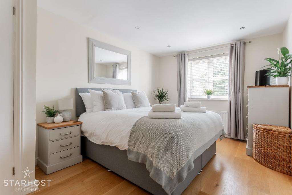 Modern 2 bed apartment at Imperial Court, Newbury في نيوبري: غرفة نوم بسرير كبير مع مرآة