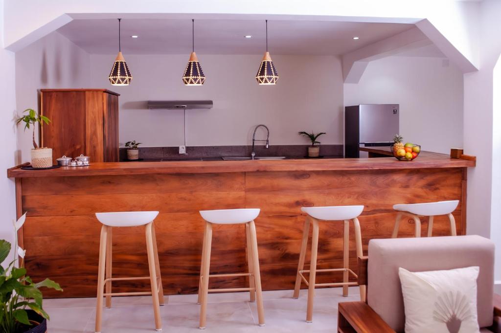 a kitchen with a wooden bar with stools at Ampifitia Guest House in Antananarivo