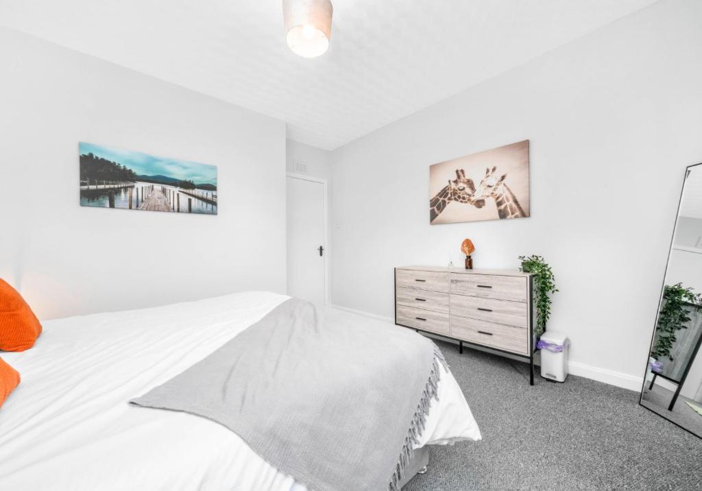 a white bedroom with a bed and a dresser at McCulloch Apartment by Klass Living Uddingston in Uddingston
