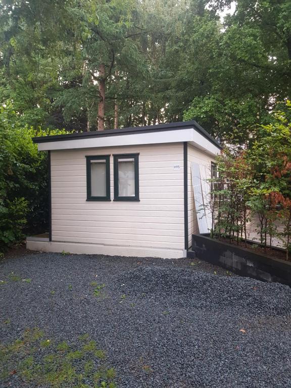 um pequeno barracão branco com uma janela em H15, Sauna- en Wellnesschalet geschikt voor 2 personen em Epe