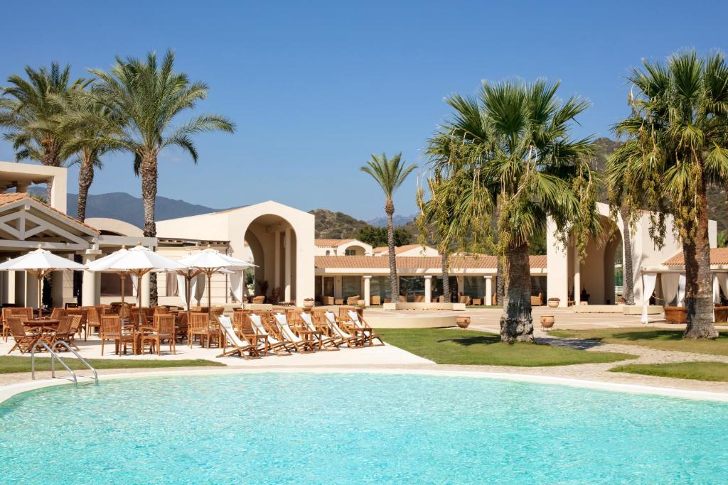 een resort met een zwembad, stoelen en palmbomen bij Spiagge San Pietro, a charming & relaxing resort in Castiadas