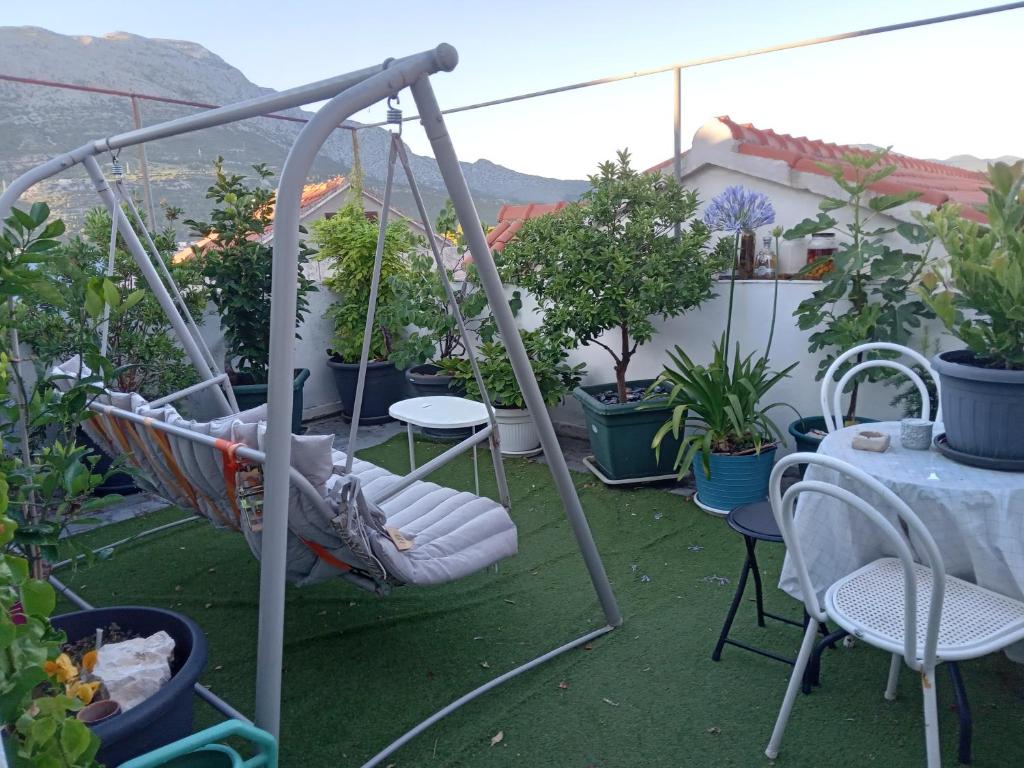 un porche con columpio, sillas y plantas en Guest House Jungher, en Korčula