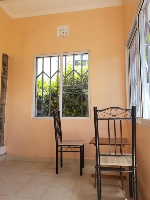 einen Tisch und einen Stuhl vor einem Fenster in der Unterkunft Allamanda Gardens Resort in Nakuru