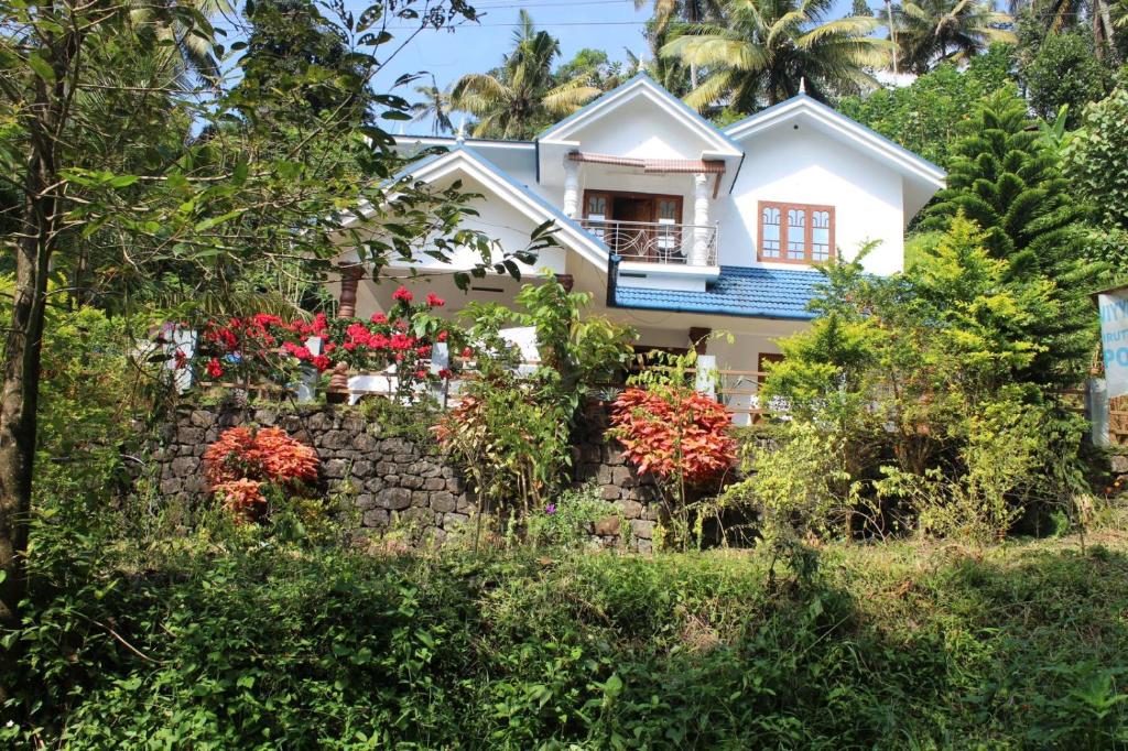 dom z kwiatami przed nim w obiekcie Munnar Village Homes w mieście Munnar