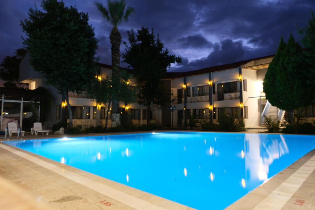 a swimming pool in front of a building at night at Artemis Yörük Otel Pamukkale in Pamukkale