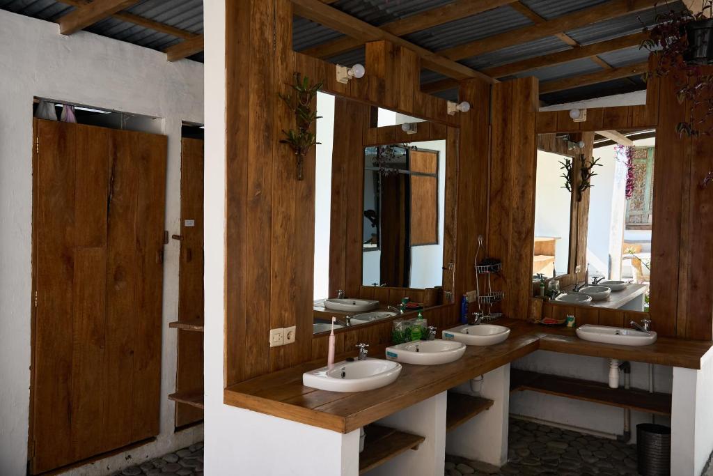 a bathroom with four sinks and two mirrors at Chakra Tavern in Bedugul