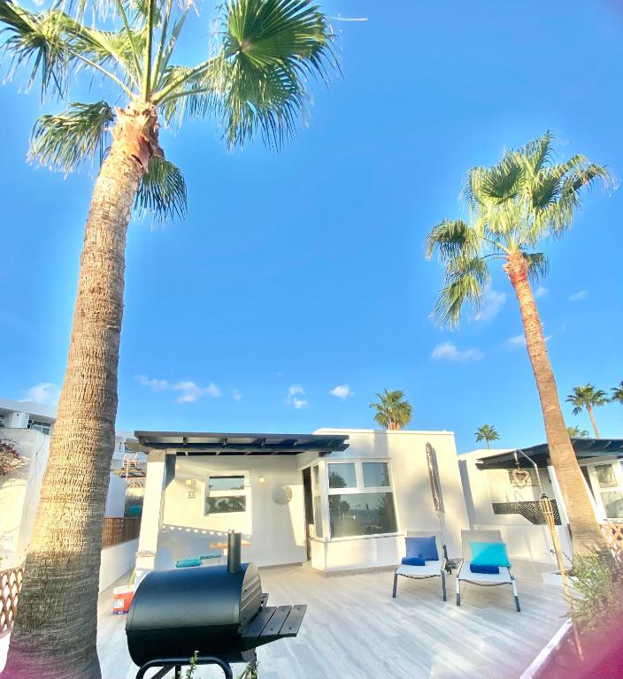 a house with palm trees and a motorcycle in front of it at Los Marinos 36 in Puerto del Carmen