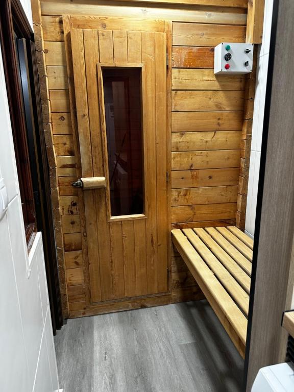 ブリアナにあるAM houseの木製のドアとベンチ付きの木製サウナ