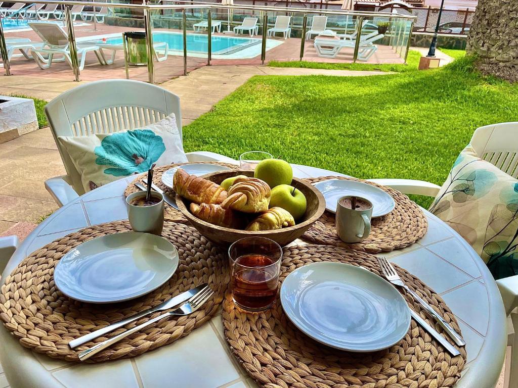 un tavolo con un cesto di frutta e un piatto di pane di Los Balandros 106 by SunHousesCanarias a San Agustin